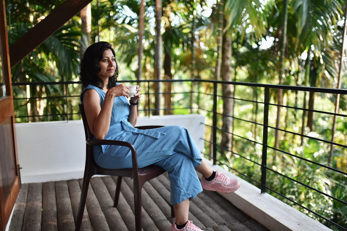 Mom sitting on porch wearing jumpsuit