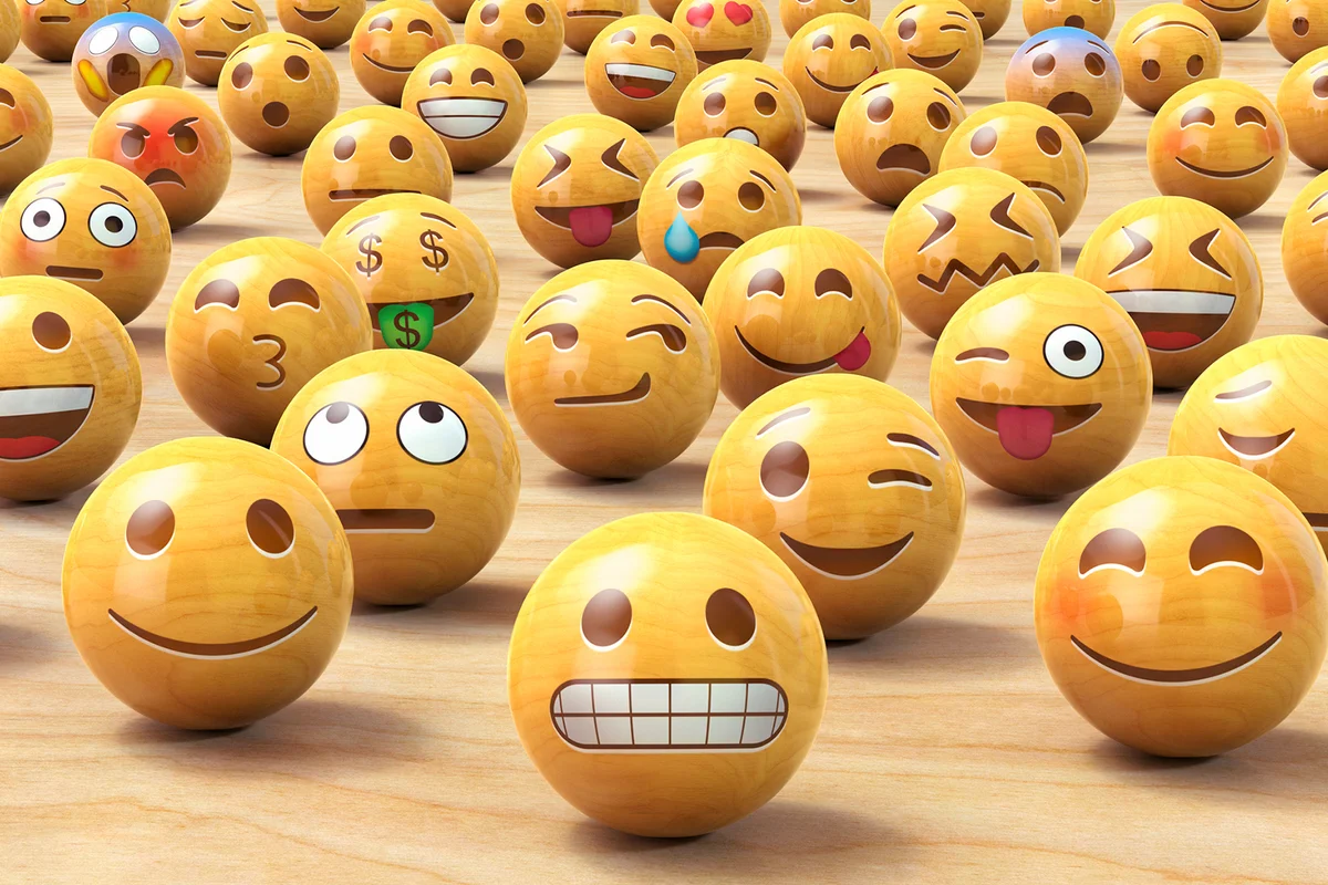 Many wooden emoticon or Emoji face balls, one up front