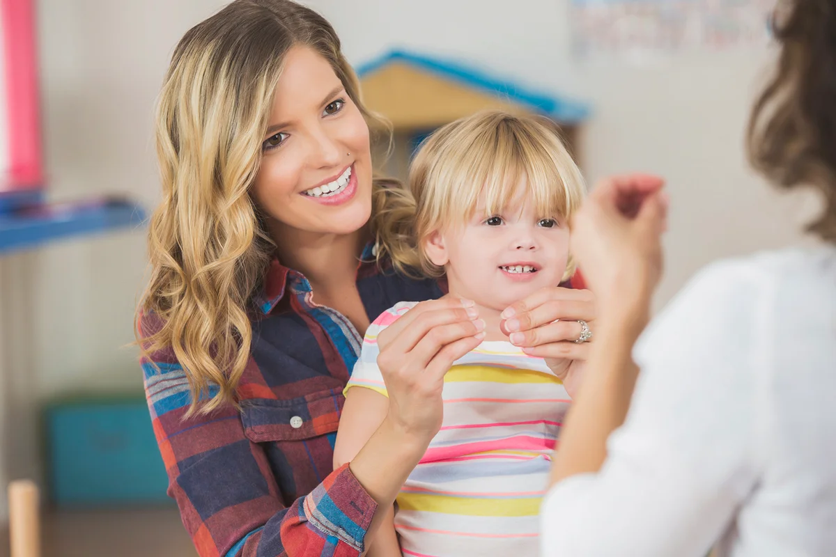Mother and toddler daughter practice sign language