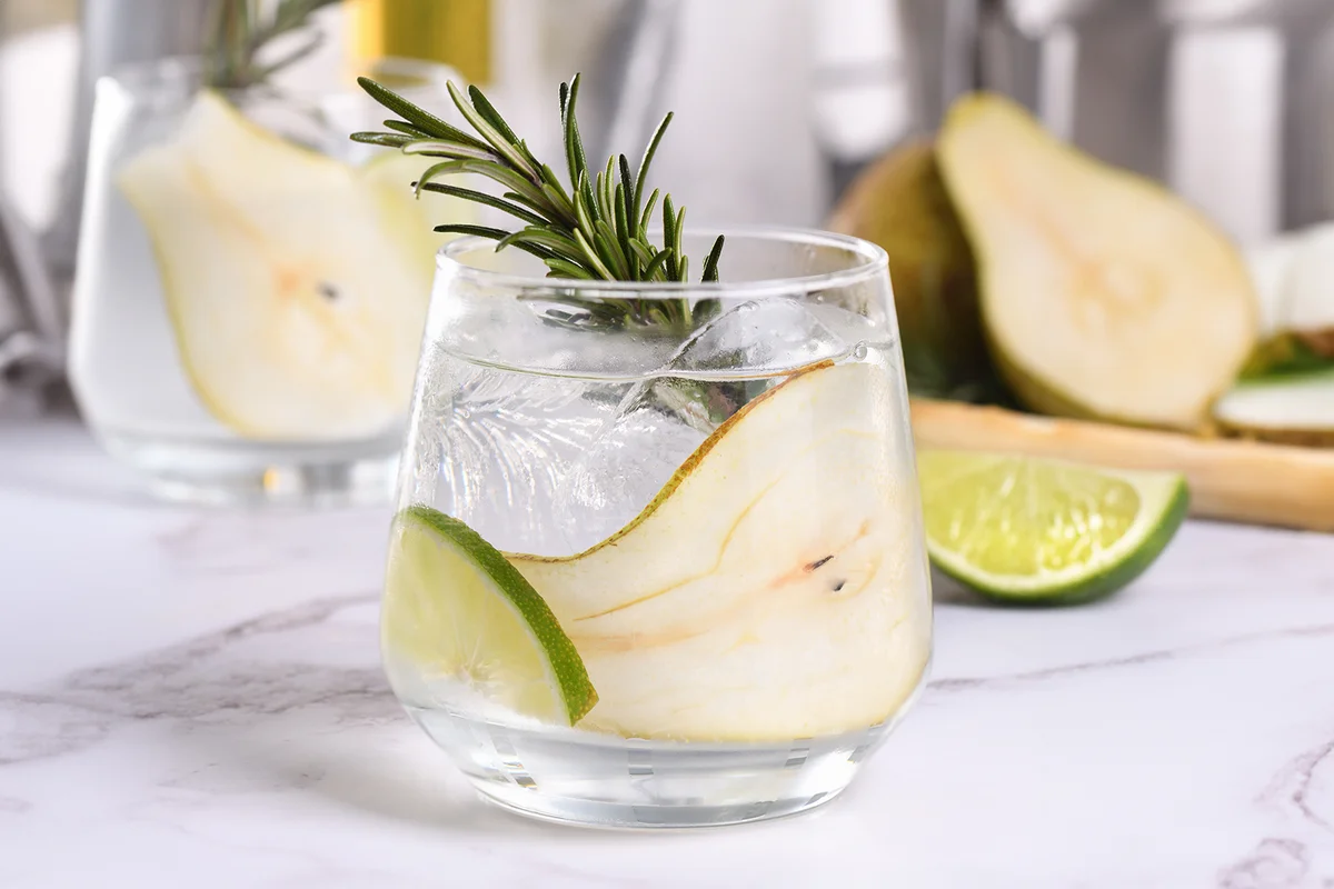 Cocktail with lime, rosemary, ripe pear and tonic
