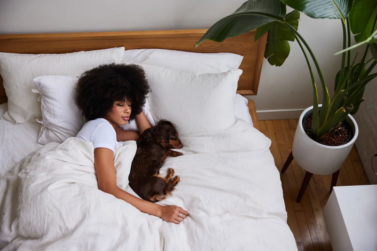 Woman laying in bed with her dachsund