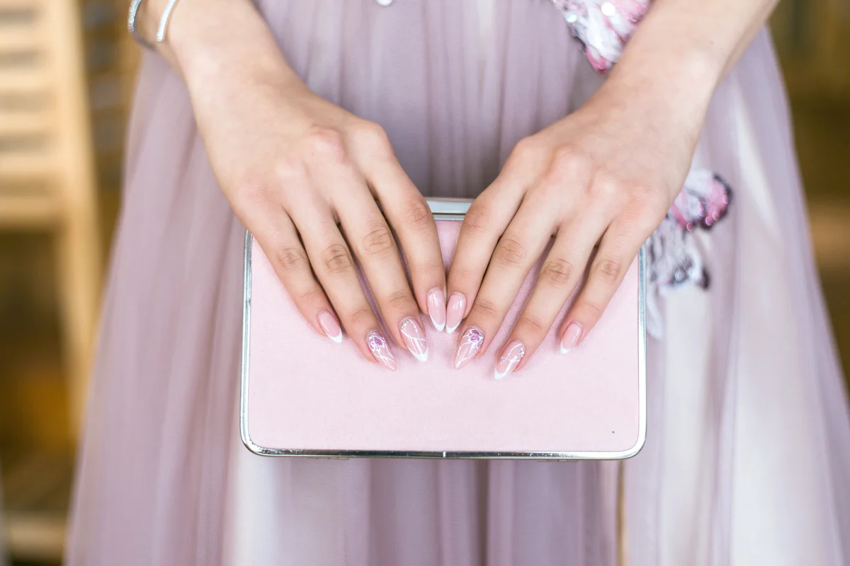Hands holding a pink clutch