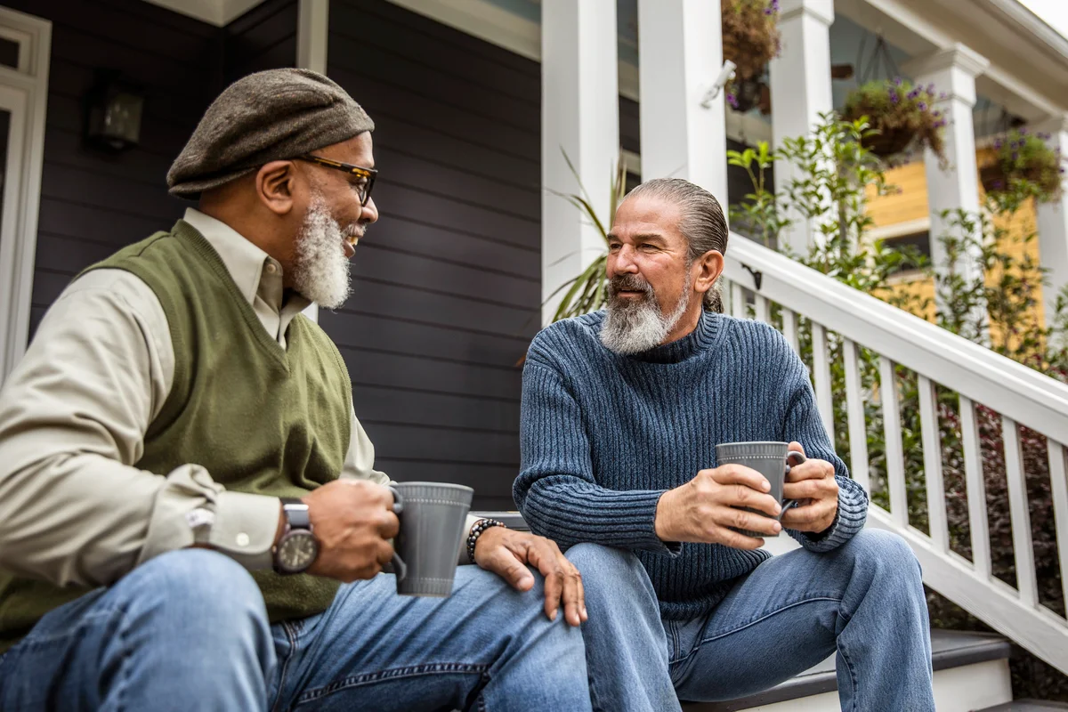 Senior men having coffee in front of suburban home