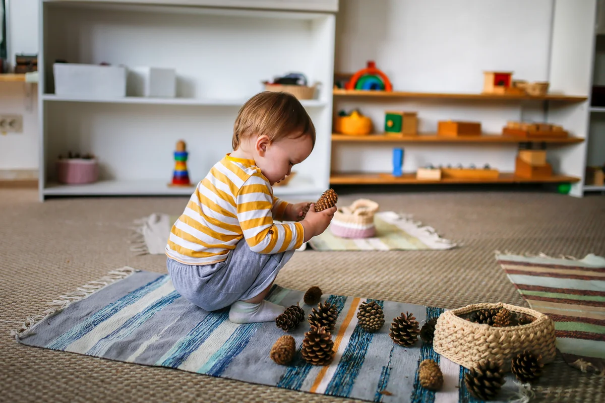 Child playing with wooden cones on floor mat
