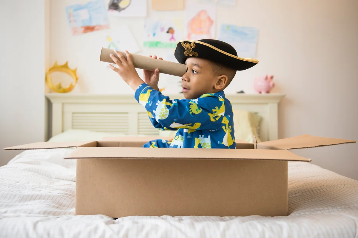 boy playing in cardboard box