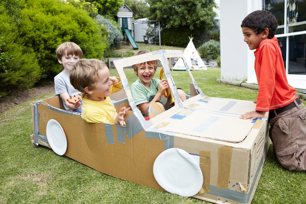 Group of boys playing in cardboard car