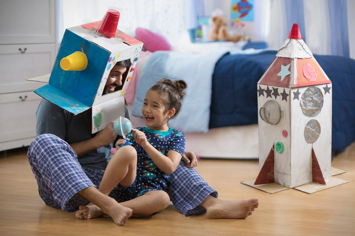 Father and daughter playing with a homemade helmet