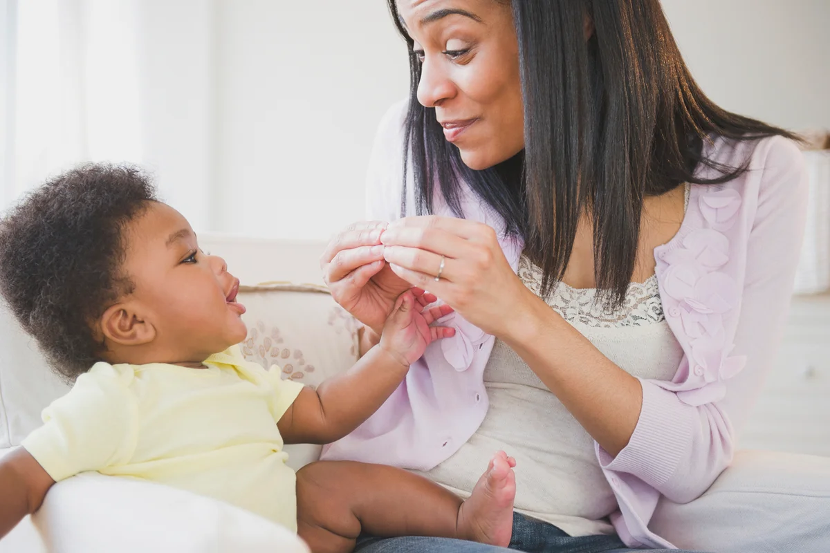 mother showing sign language to baby boy