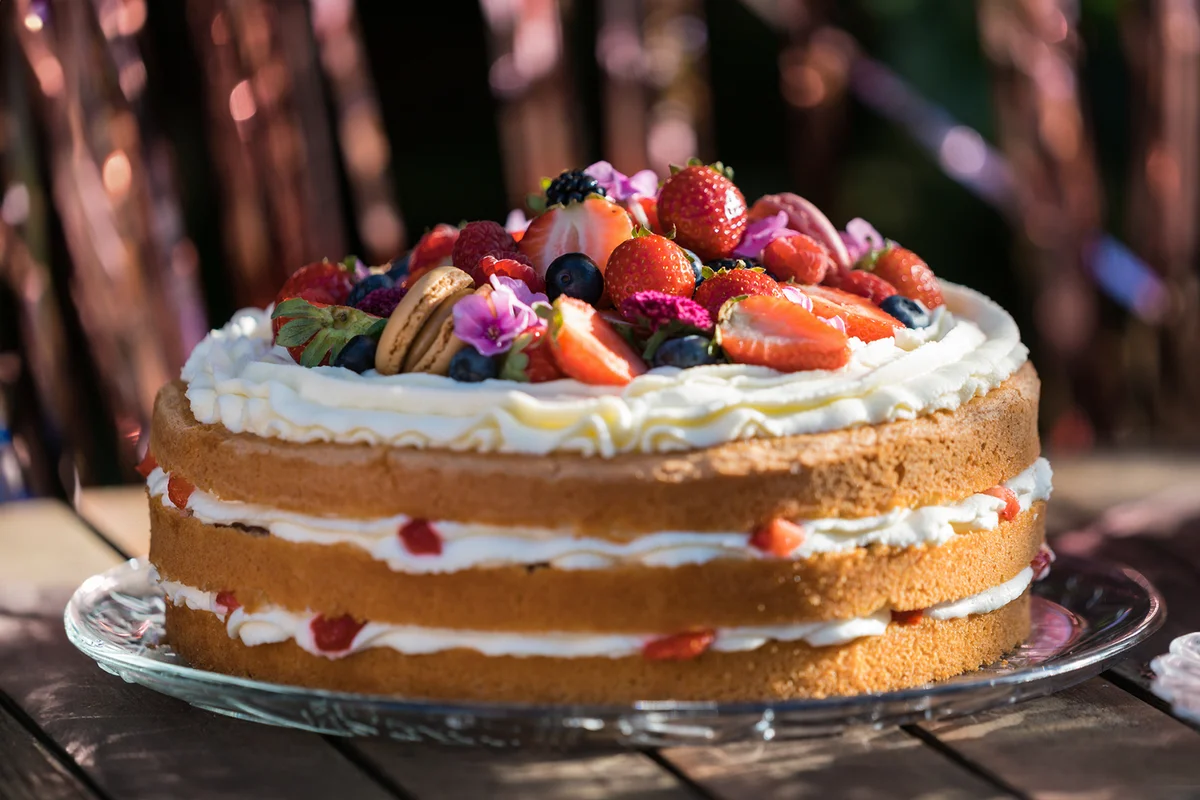 Delicious Cream Cake decorated with Fruits on a Table