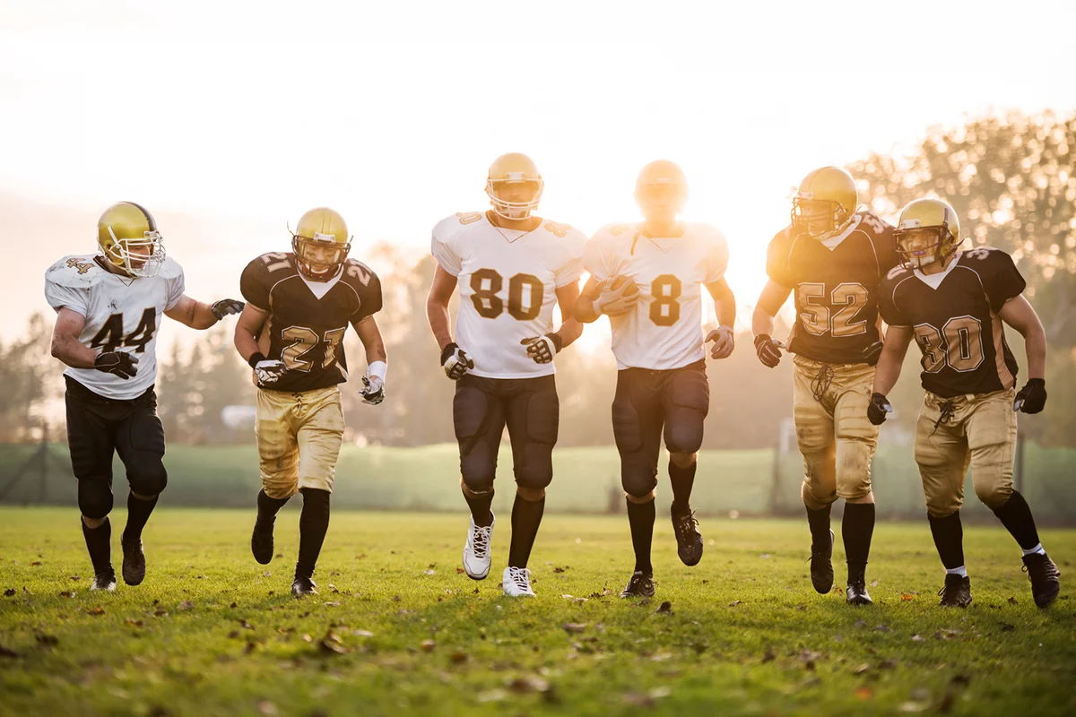 American football players running on the playing field.
