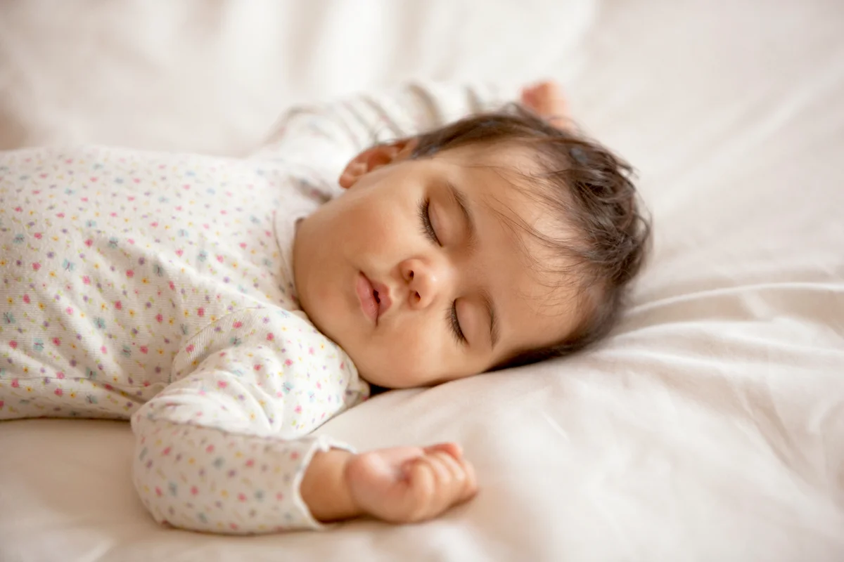 Baby girl sleeping on bed
