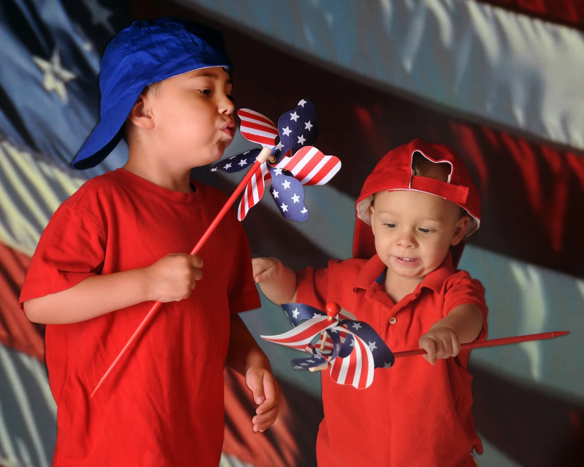 two boys in red, white, and blue with pinwheels