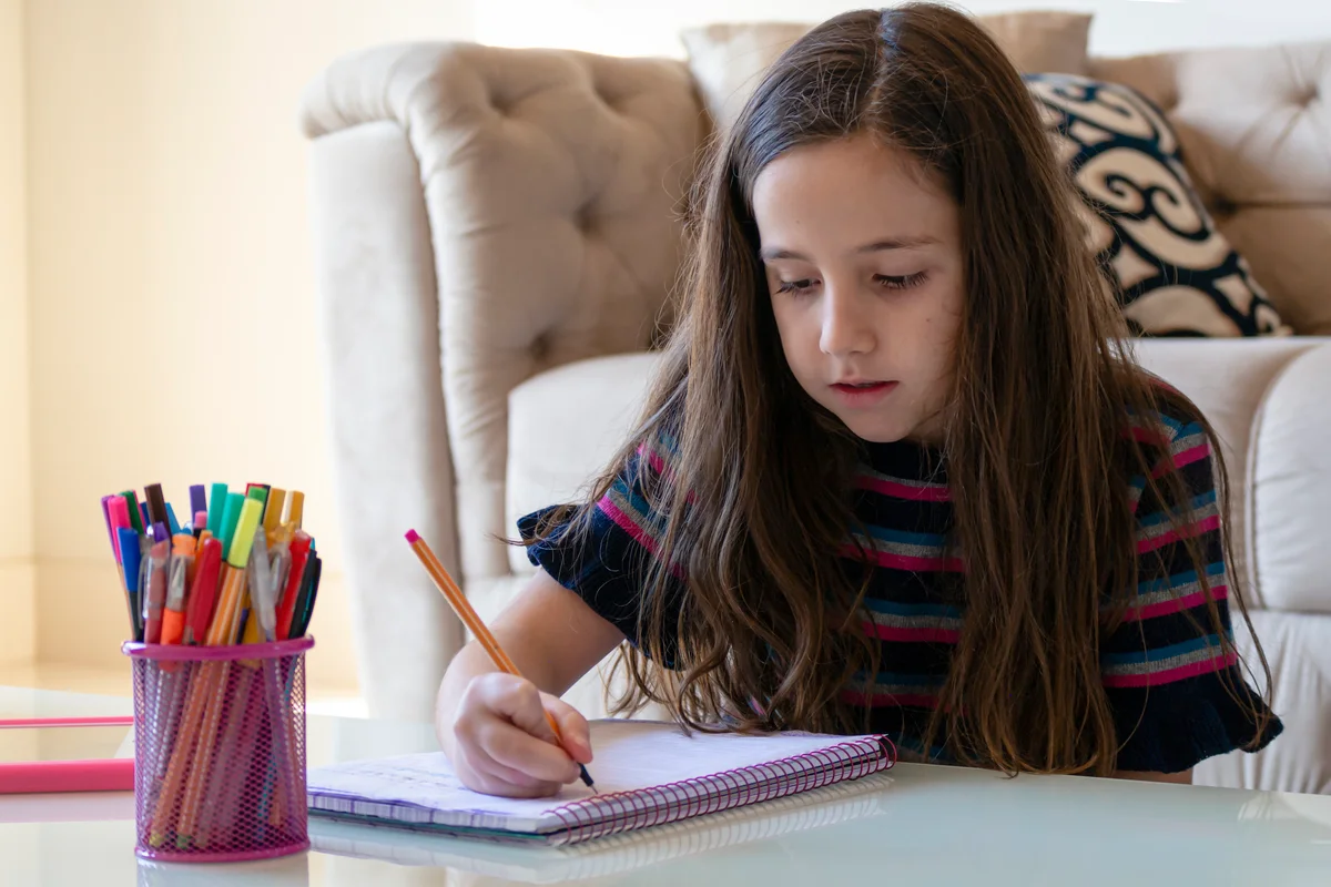 preteen writing in planner