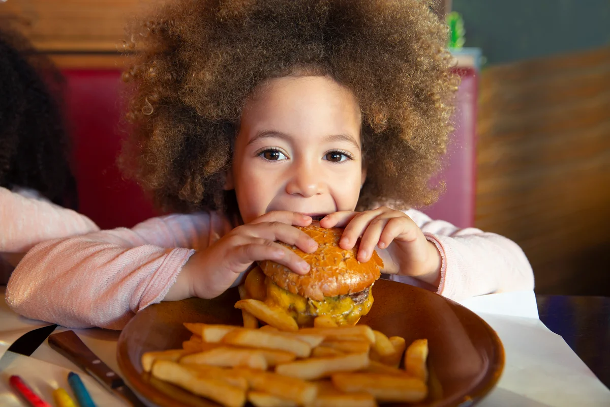 Girl eating burger and fries