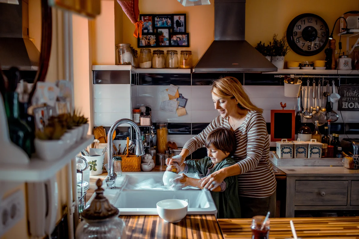 Mother and son washing dishes