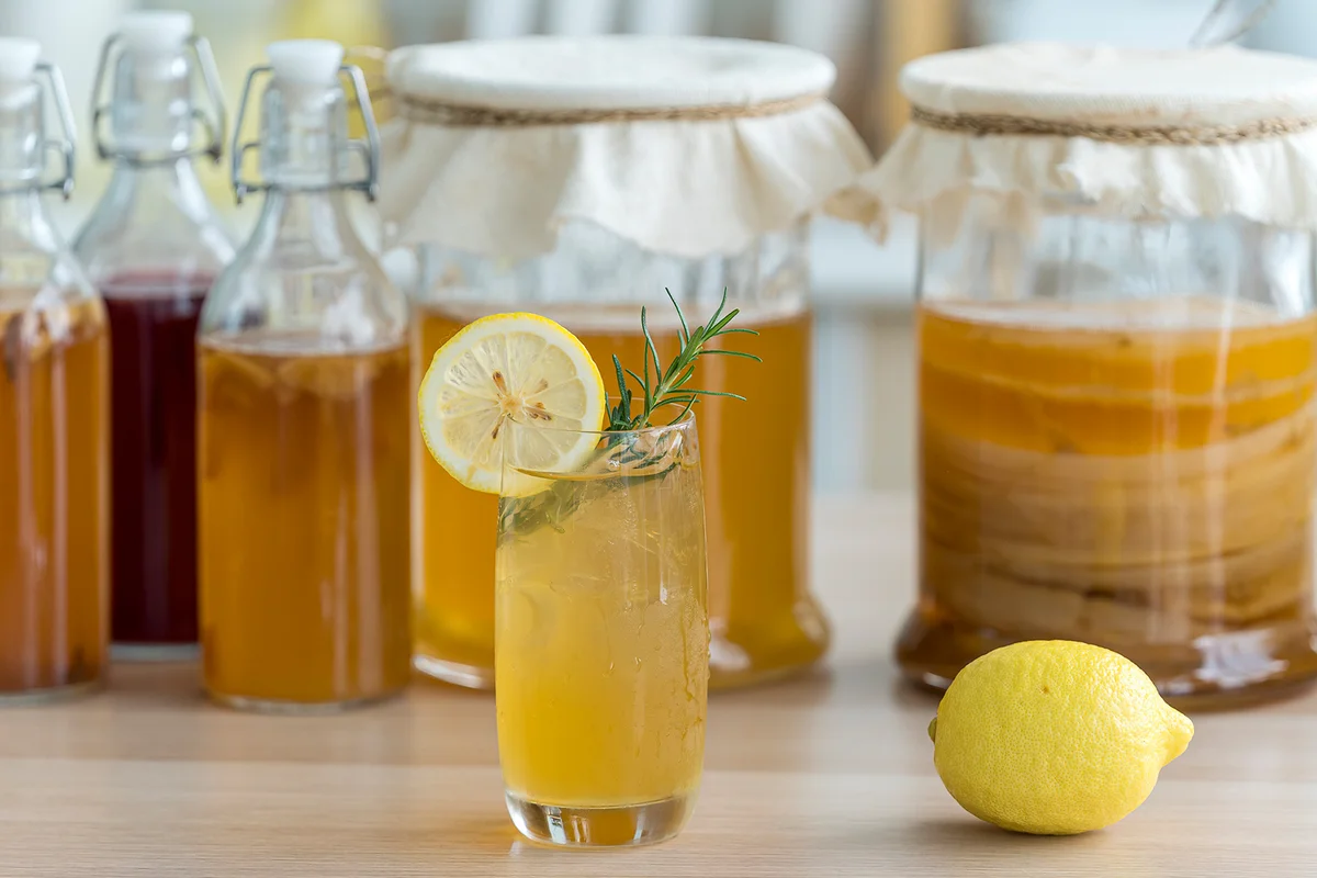 Kombucha tea with lemon and sweetened root filling in glass jug