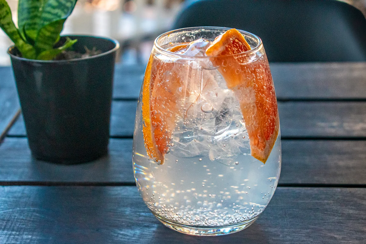 Glass of lemonade with slices of grapefruit and ice