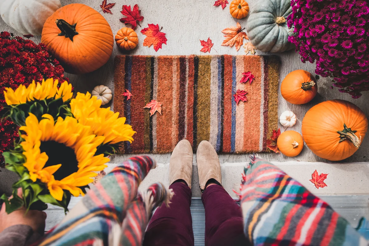 Woman standing in doorway surrounded by fall decor