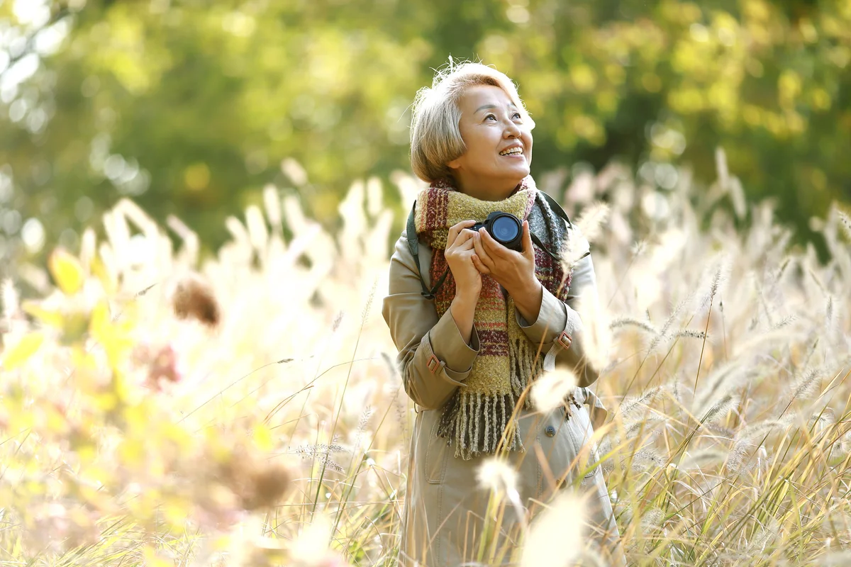 woman in a field of grass taking photos