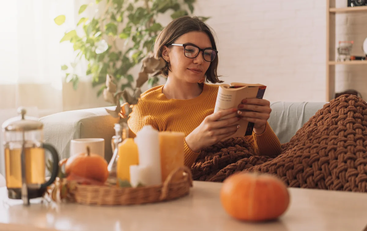 woman with a cup of tea reading a book