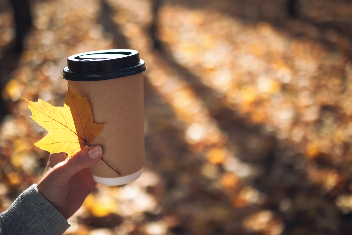 hand holding a leaf and a cup