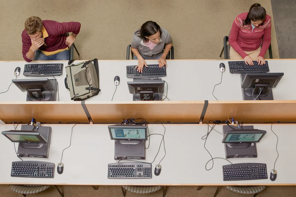 Three college students working in computer lab