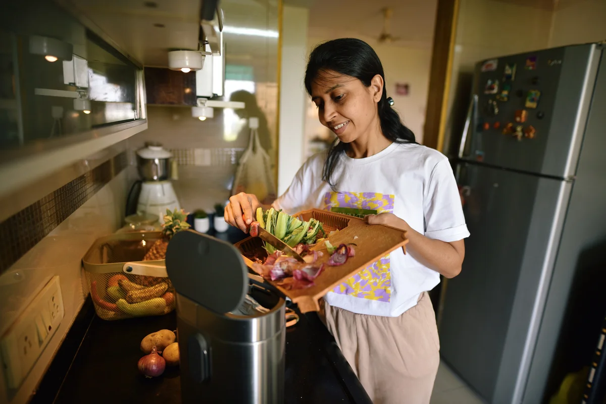woman scraping food waste into garbage