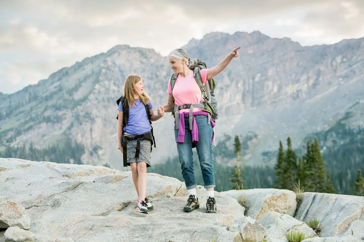 Grandmother and granddaughter hiking on mountain