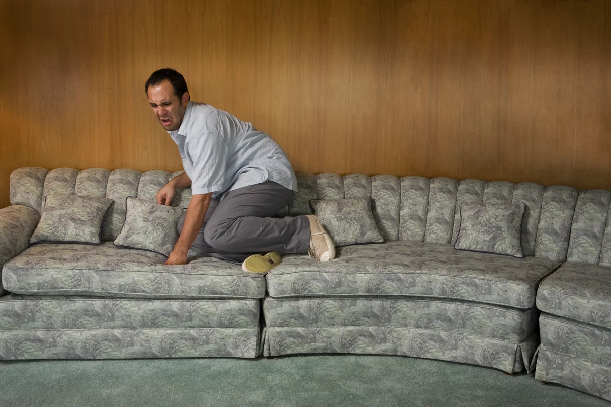 Man on couch afraid of something