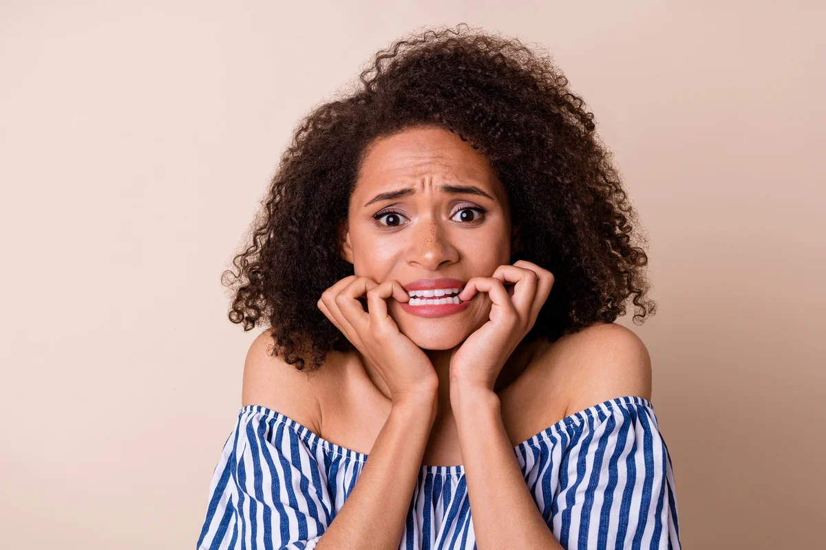 Scared woman biting her nails