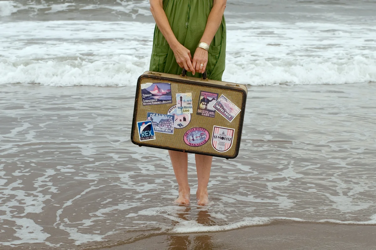 Girl with suitcase in sea