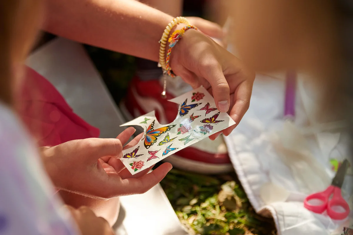 Children paper crafting with parents in outdoor children party,