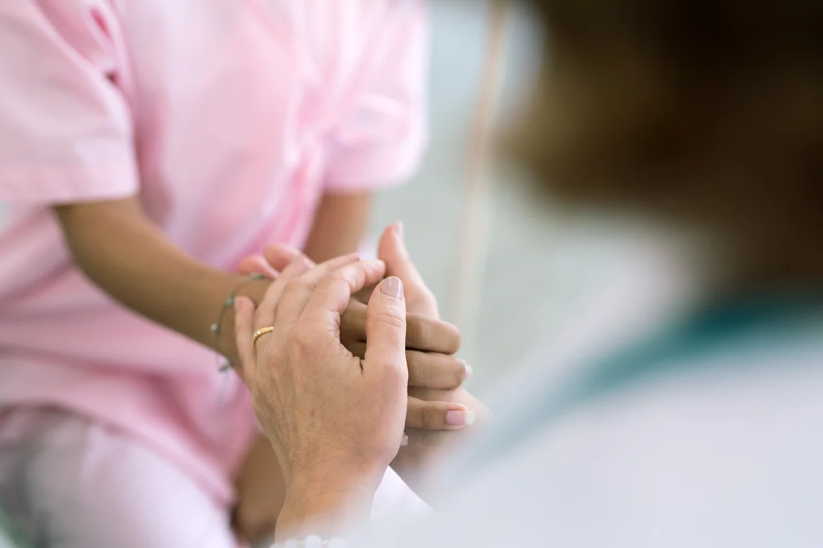 Close up of doctor holding patient's hand,