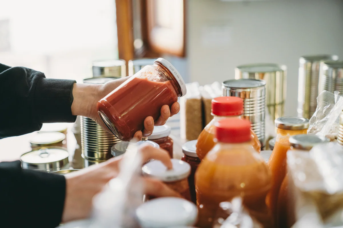 Woman is rearranging food in pantry
