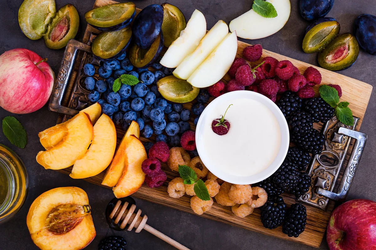 Various kind of berries and fruits served with fruit dip