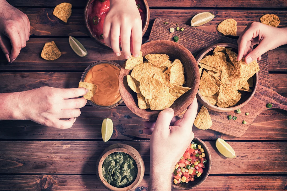 Family Eating Nachos With Sauces