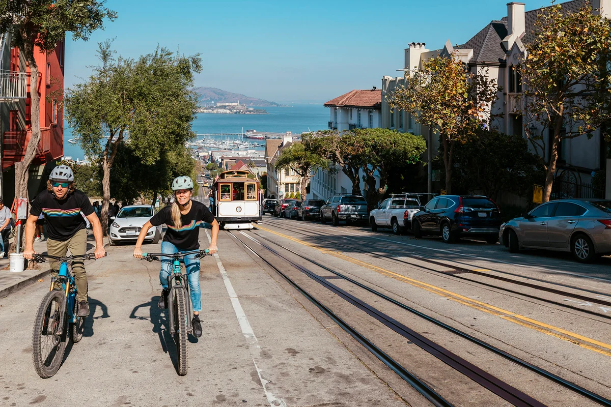 couple ride up sunny city street