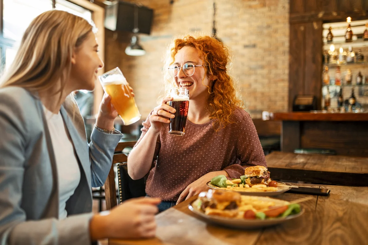 Two girl friends enjoying beer at the bar