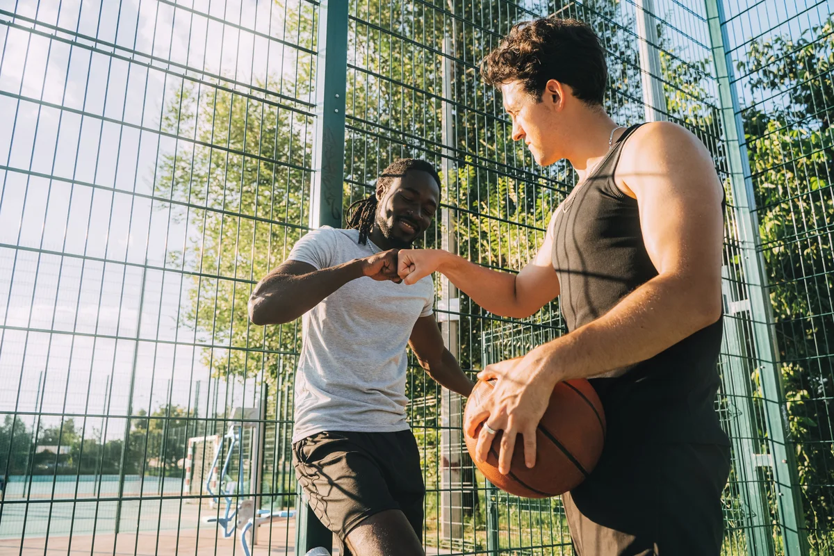 Guys playing basketball and bumping fists