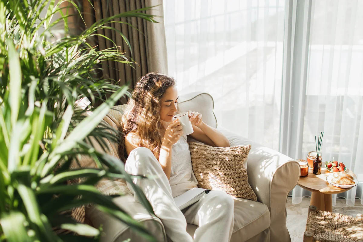 Woman looking happy while she enjoys morning coffee