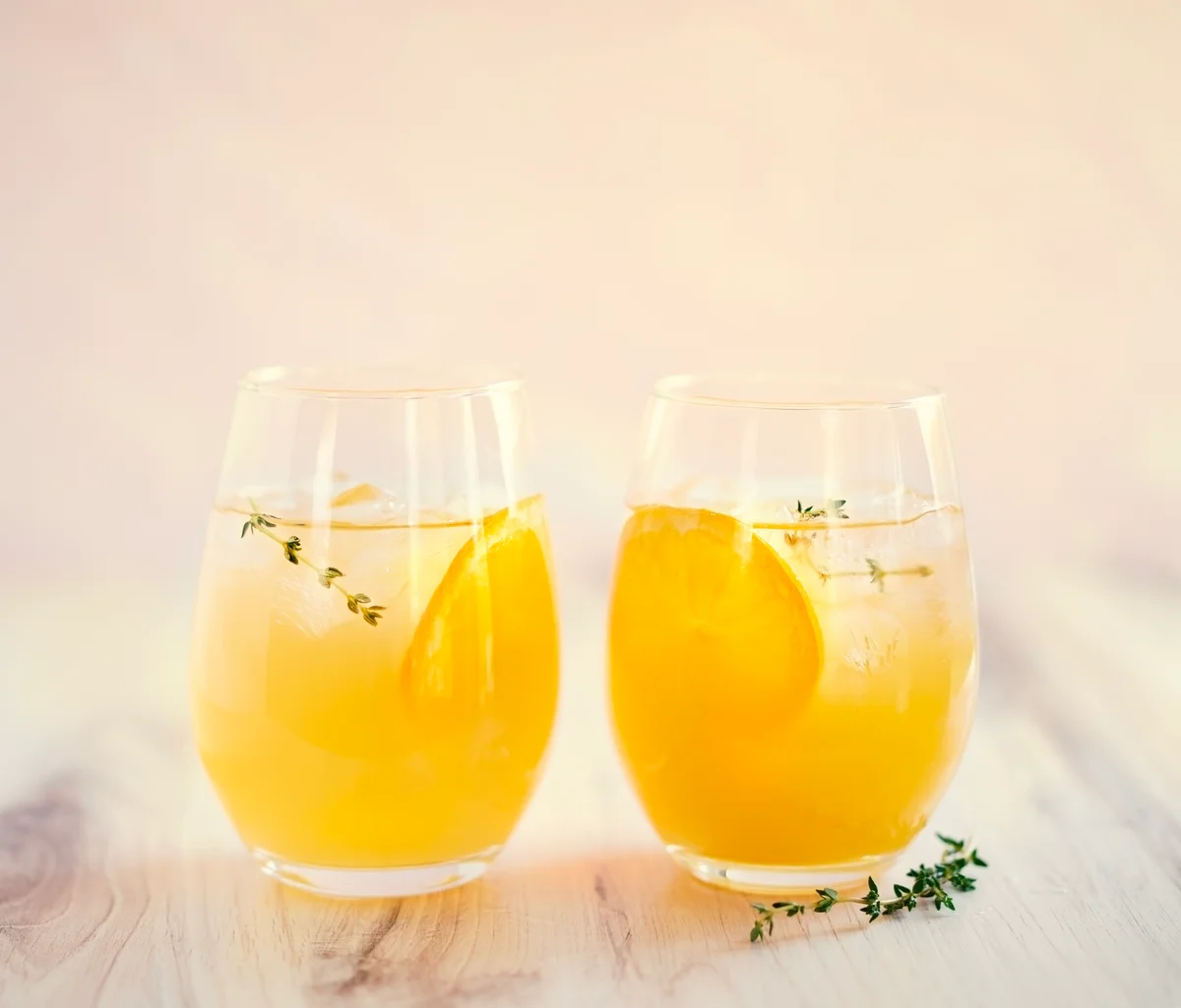 slice of thyme peach mocktail garnished with orange and thyme