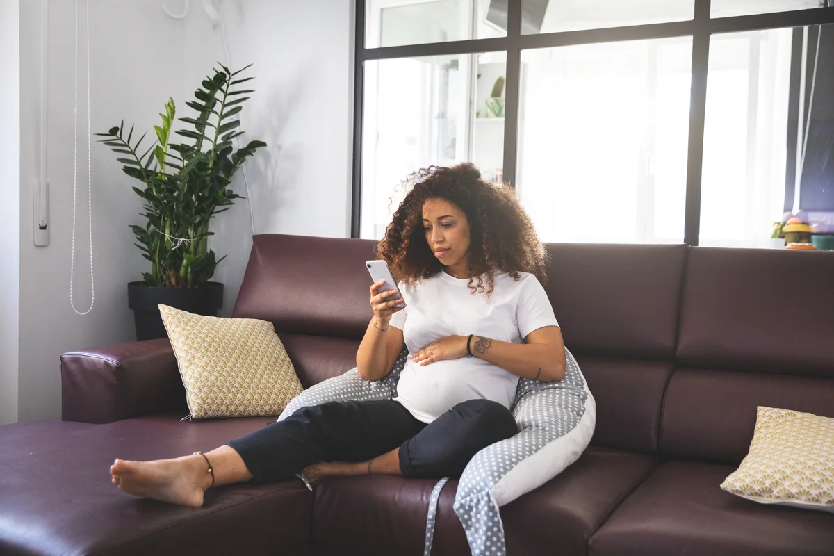 Pregnancy woman relaxing on couch with pillow for support