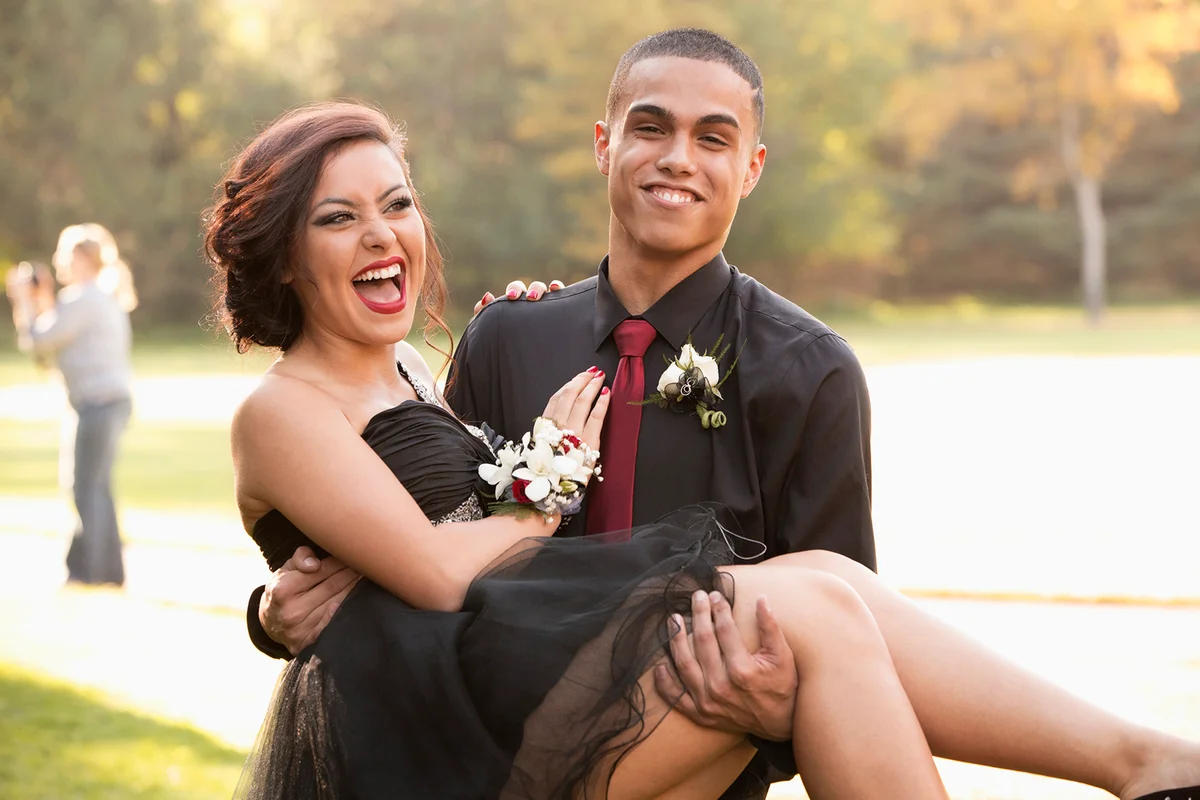 Teenage boy carrying prom date