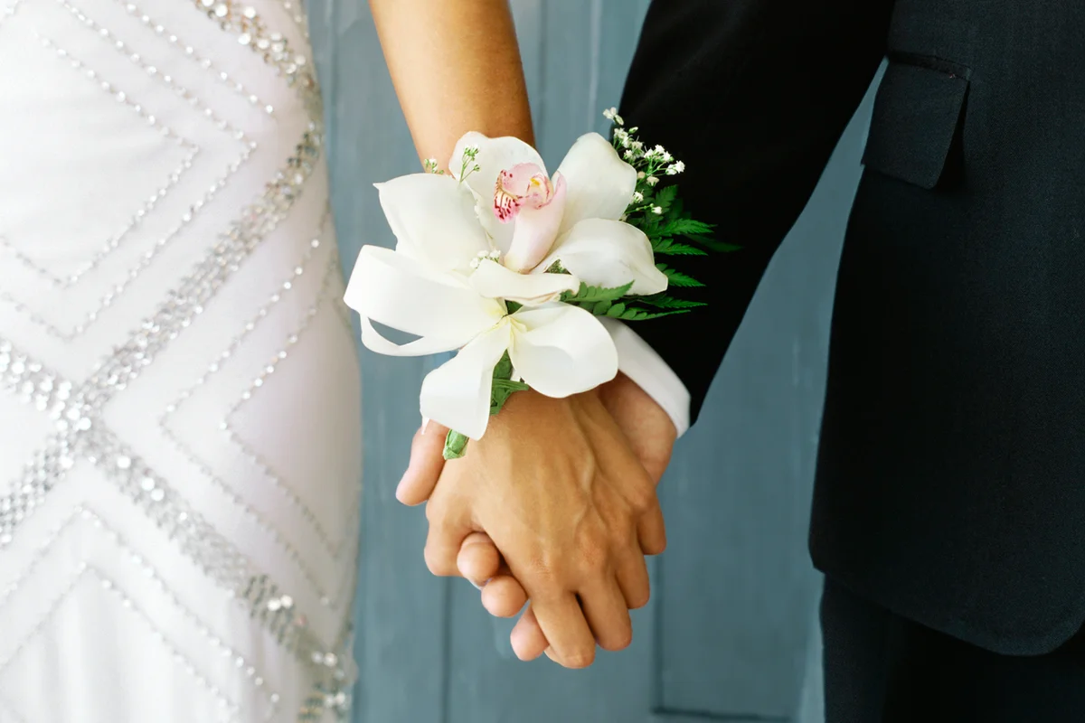 Mid section view of a teenage couple holding hands
