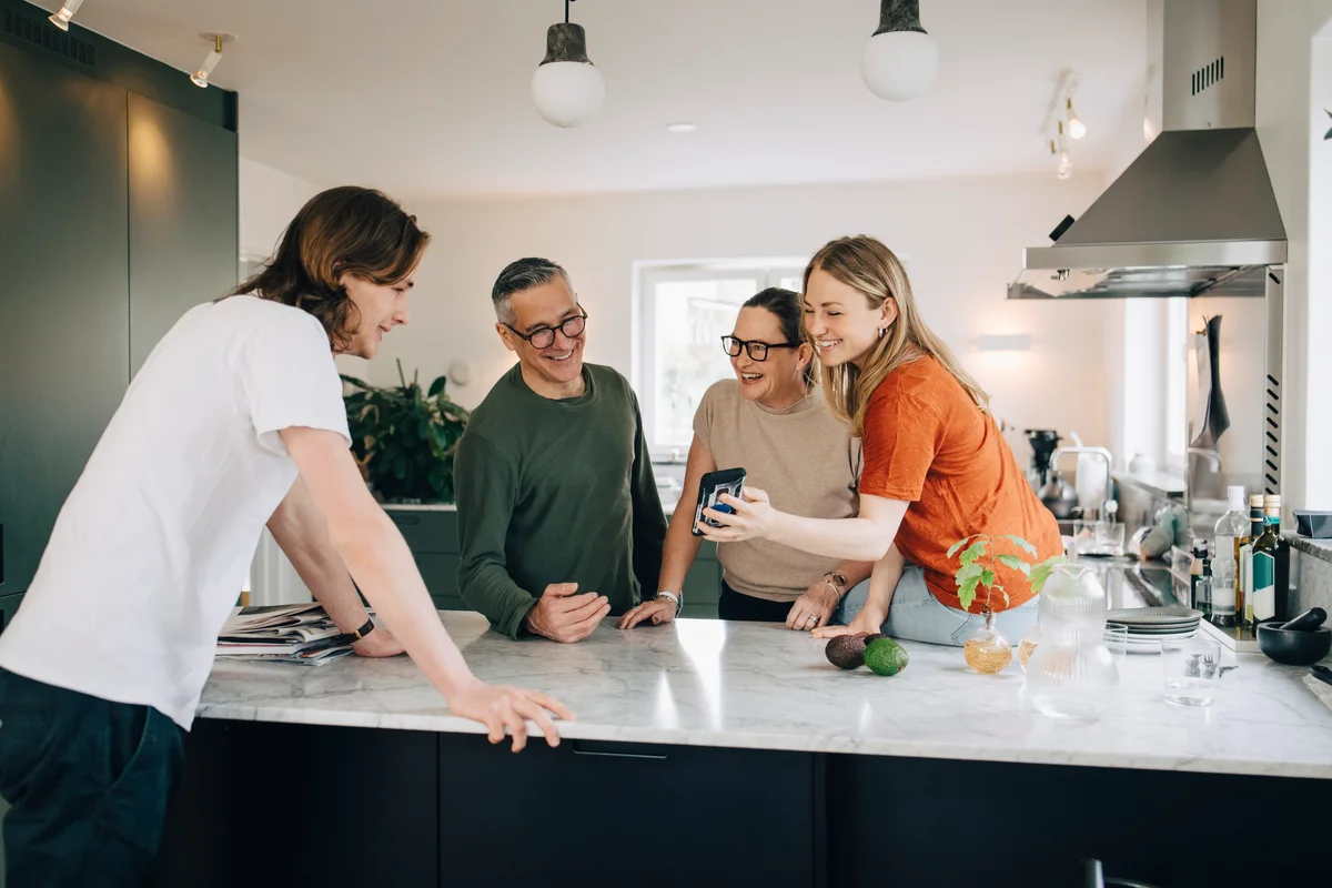 College student visiting family showing them her phone
