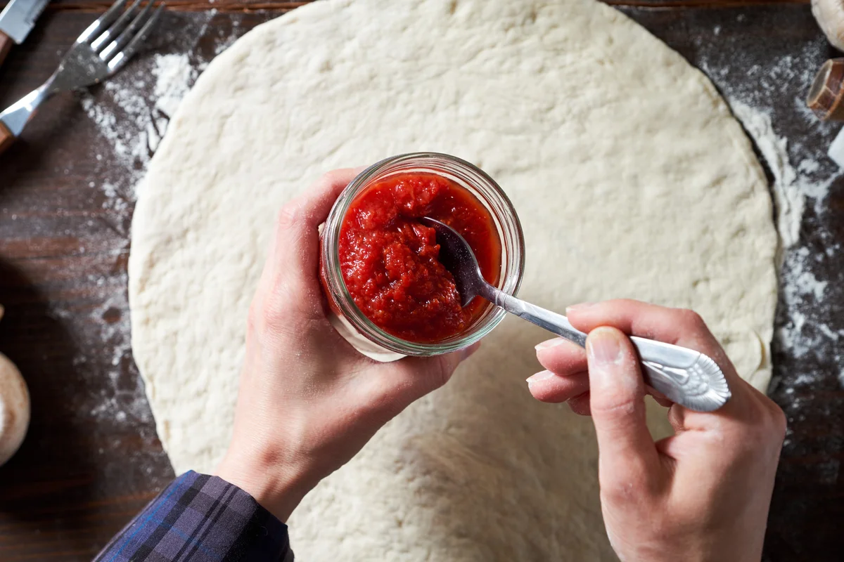 Home made pizza sauce going onto dought
