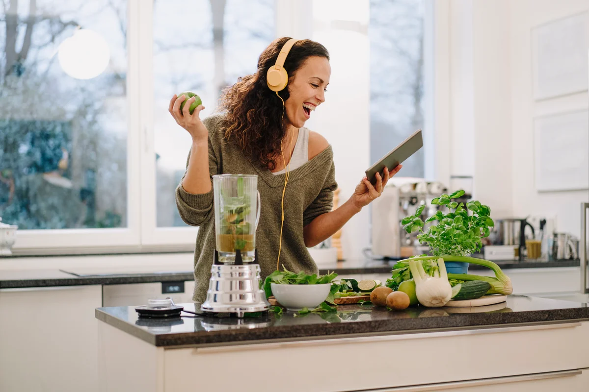 Woman happily blending various foods