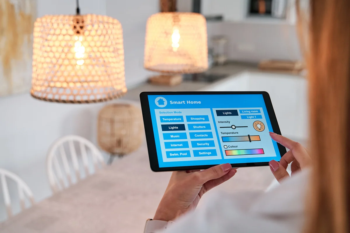 Woman using an app on her smartphone to control the lighting in her smart home