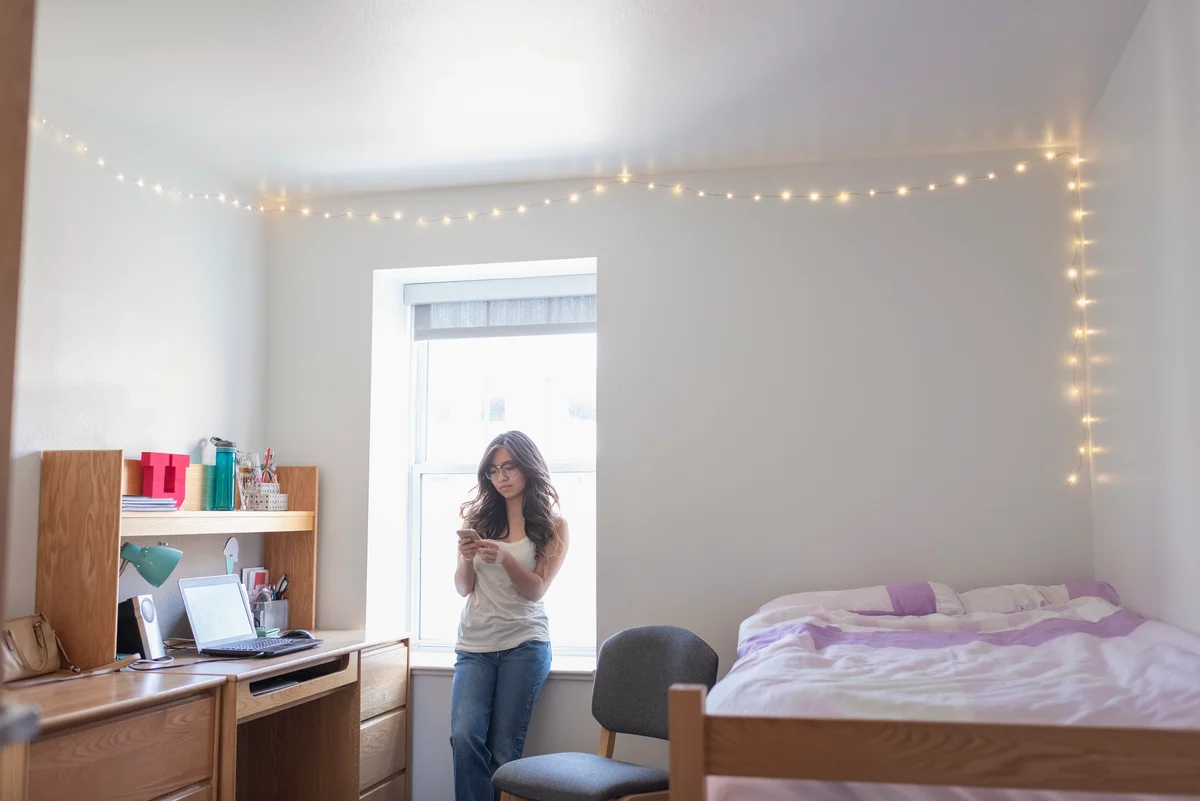 student in dorm with string lighting