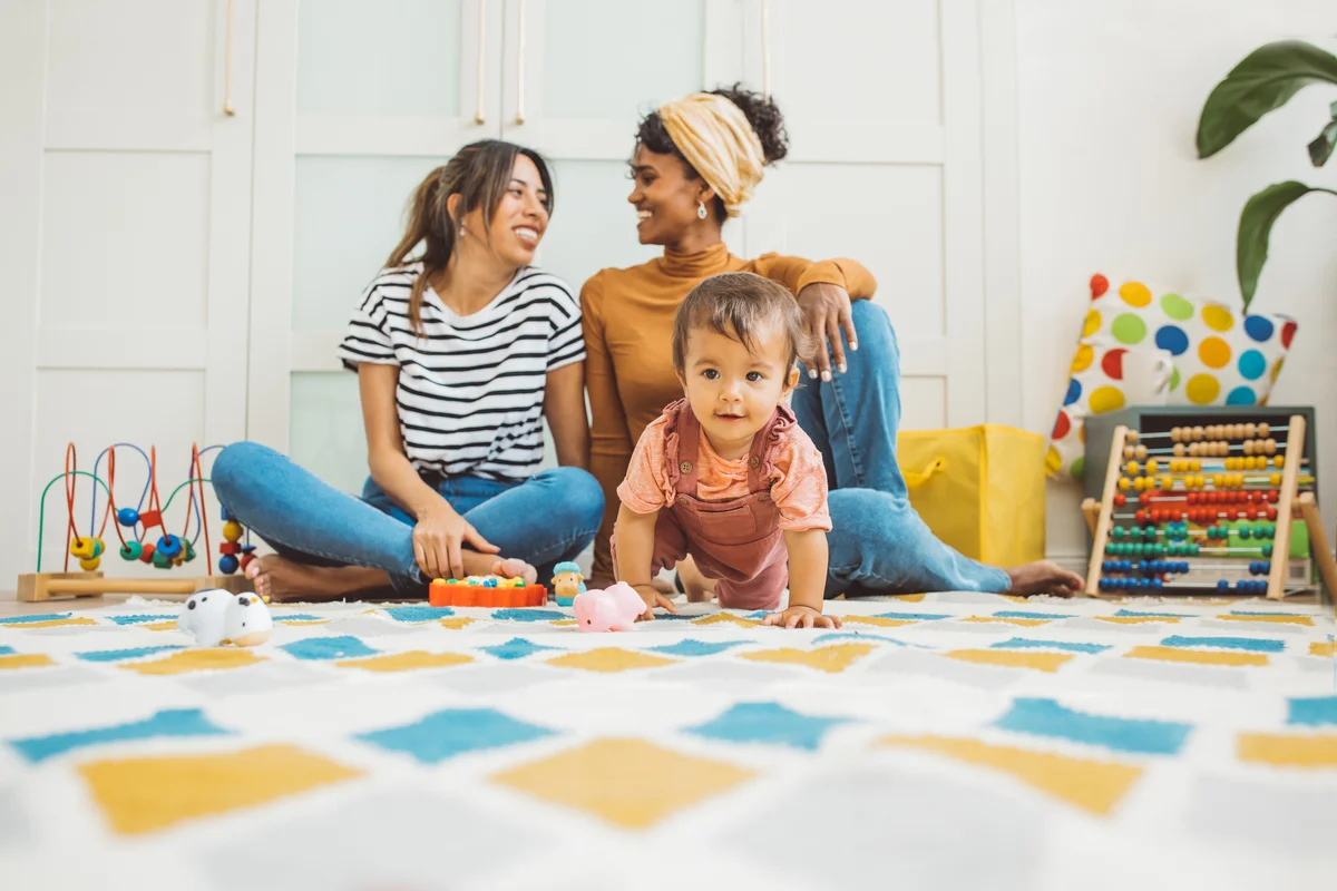 Two moms watching their daughter play